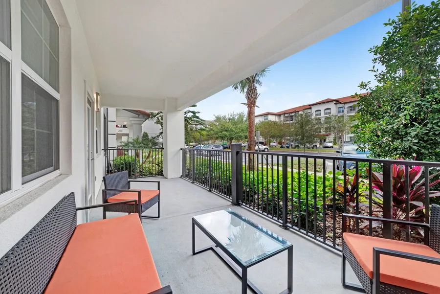 Private patio with orange chairs and palms