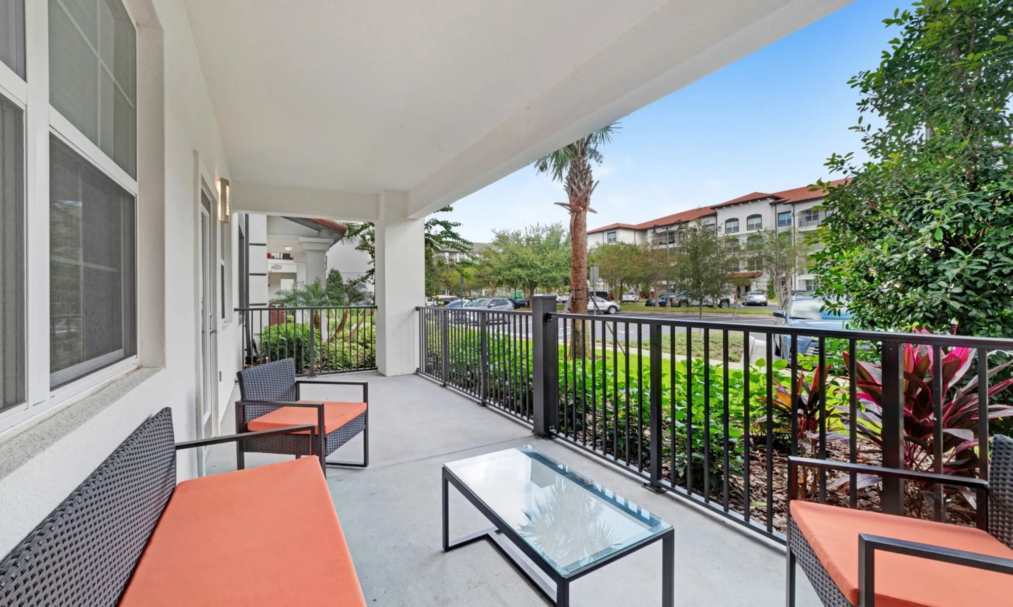 A private patio with orange chairs, palms and open sky at Vista Cay